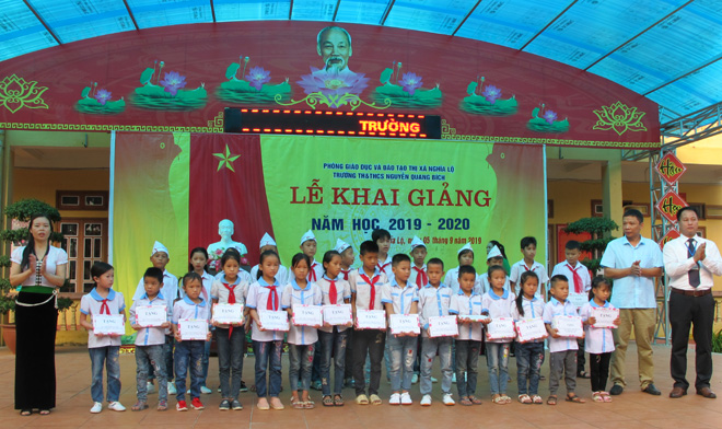 Ban Giám hiệu và Hội Phụ huynh học sinh Trường TH&THCS Nguyễn Quang Bích trao quà cho học sinh nghèo vươn lên trong học tập nhân dịp khai giảng năm học mới 2019 - 2020.